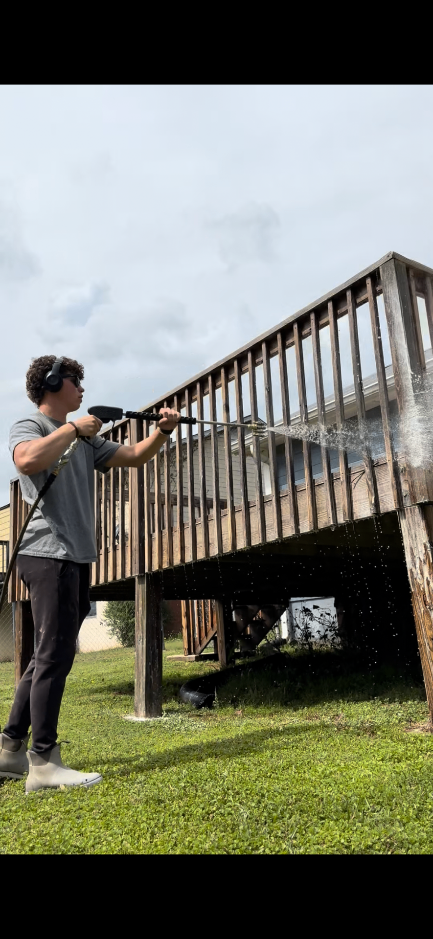 Eli Stokley pressure washing a deck